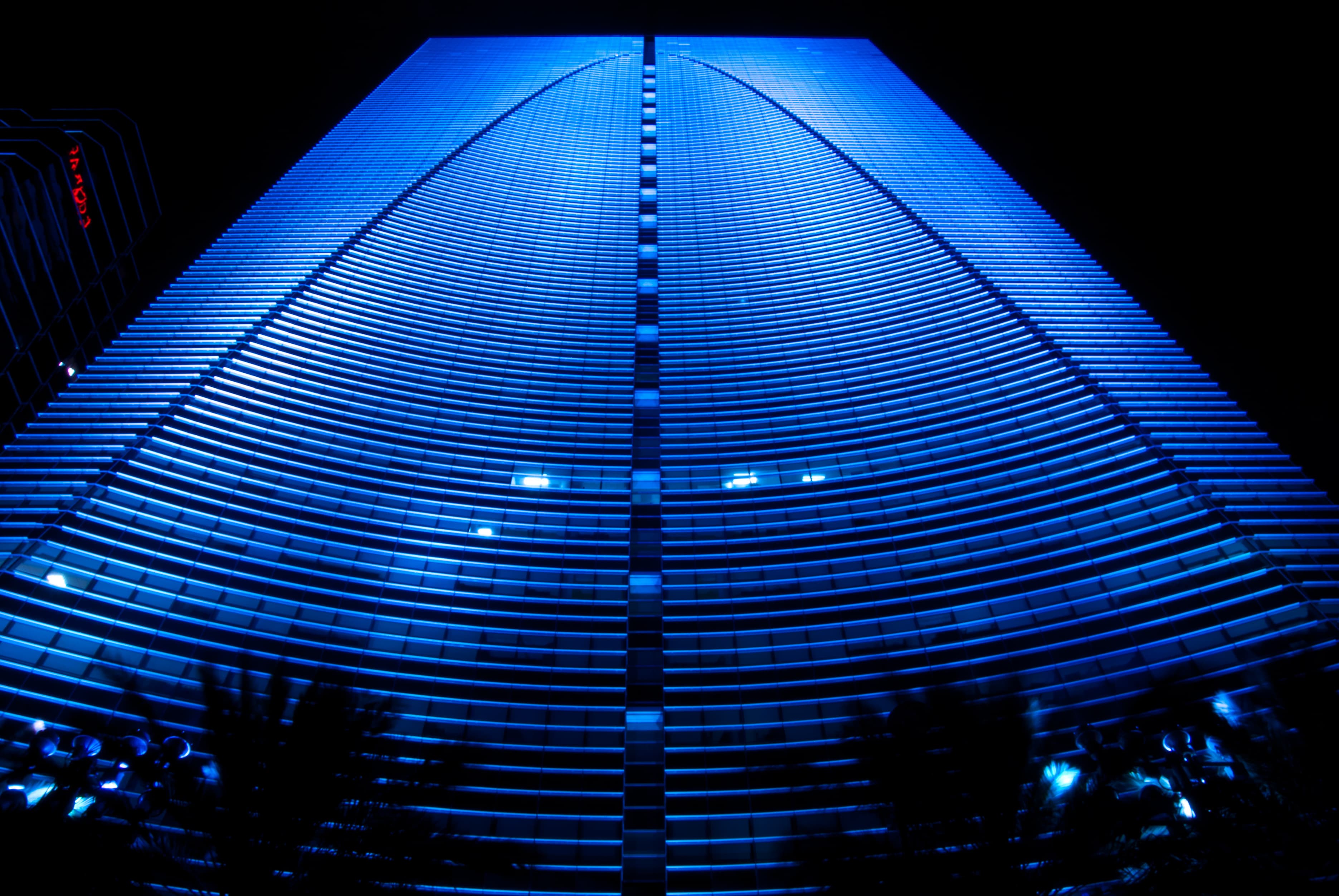 Brickell Arch at night — looking up at the curved glass façade of 1395 Brickell Ave, Miami